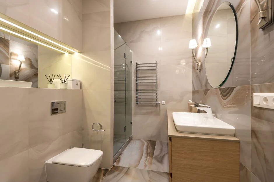 A hotel housekeeper neatly stacks fresh towels in a luxurious room setting.