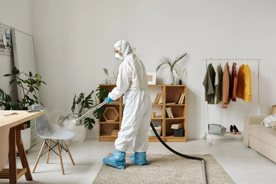 A professional housekeeper is holding a stack of fresh towels in a luxurious hotel room, reflecting elegance and attentive service.
